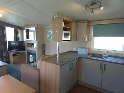 a kitchen with a couch and a sink in a room at Caravan in Picturesque New Quay Wales in New Quay