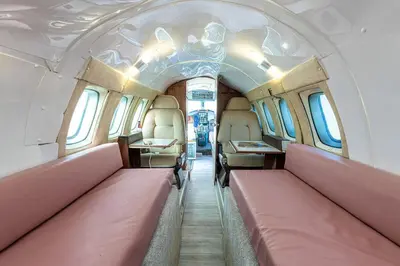 a train car with pink seats in the aisle at Alaya Airways in Dolgellau
