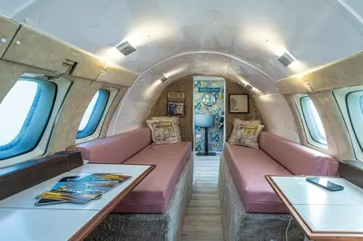 a train room with pink seats and a table at Alaya Airways in Dolgellau