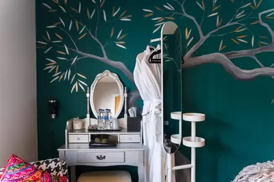 a bedroom with a green wall with a tree mural at Maes Bach Boutique GUEST HOUSE TOWN CENTRE in Aberystwyth