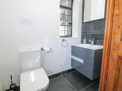 a bathroom with a white toilet and a sink at Bwthyn y Coediwr The Woodcutters Cottage in Blaenau-Ffestiniog