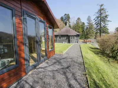an exterior view of a house with large windows at Bwthyn y Coediwr The Woodcutters Cottage in Blaenau-Ffestiniog