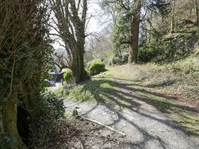a dirt road with trees on the side of it at Bwthyn y Coediwr The Woodcutters Cottage in Blaenau-Ffestiniog