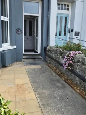 a front door of a house with pink flowers at Seasalt Apartment in Barmouth