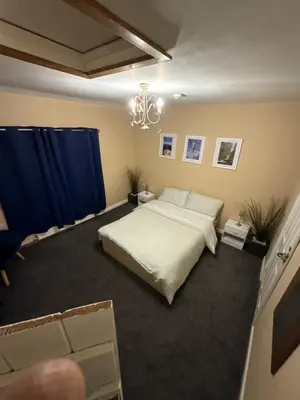 a bedroom with a bed and a blue curtain at Dine & Rest, 1 bedroom apartment at little India in Llanrhaeadr-ym-Mochnant