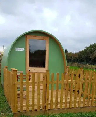 a small green dome house with a wooden fence at Green Dragon and Kitchen Pod - Sleeps 2 & Parking in Welshpool