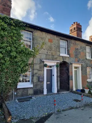 a brick house with a white door and windows at No 3 Waterloo Place in Welshpool