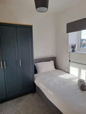 a bedroom with a bed and a cabinet and a window at No 3 Waterloo Place in Welshpool