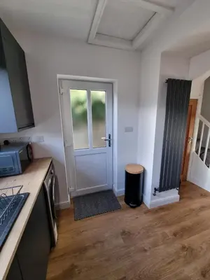 a kitchen with a door and a stool in a room at No 3 Waterloo Place in Welshpool