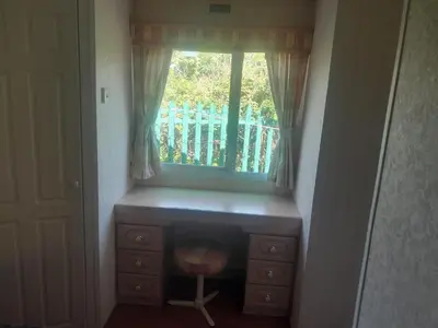 a window with a desk and a chair under it at 254 Bryn y Mor in Tywyn