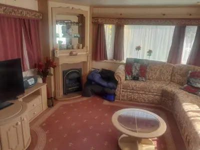 a living room with a couch and a fireplace at 254 Bryn y Mor in Tywyn