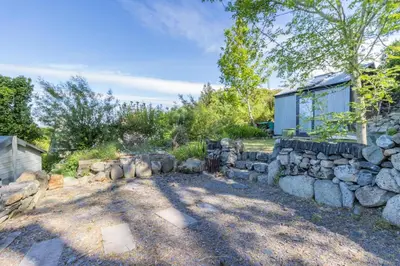 a garden with a stone wall and a yard at 1 Bed in Llwyngwril oc-a31970 in Llwyngwril