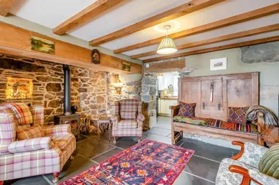 a living room with furniture and a stone wall at 4 Bed in Arthog oc-b31966 in Arthog