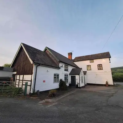 an old white barn and a white house at Green Dragon and Kitchen Pod - Sleeps 2 & Parking in Welshpool