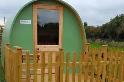 a small green dome house with a wooden fence at Green Dragon and Kitchen Pod - Sleeps 2 & Parking in Welshpool