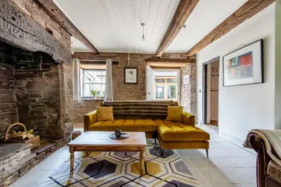 a living room with a yellow couch and a table at 4 bedroom farmhouse Brecon Beacons in Talgarth