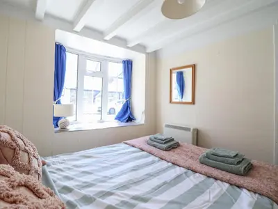 a bedroom with a bed with two towels on it at Glan Y Mor Borth in Aberystwyth