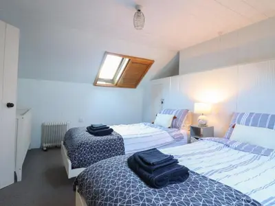 a bedroom with two beds and a window at Glan Y Mor Borth in Aberystwyth