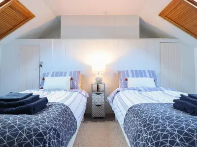 a bedroom with two beds with blue and white sheets at Glan Y Mor Borth in Aberystwyth
