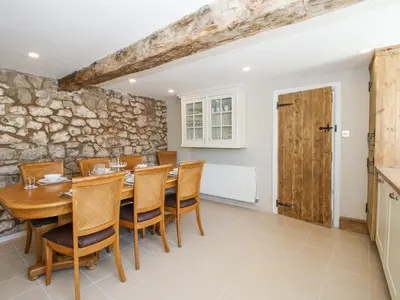 a dining room with a wooden table and chairs at Pennal Cottage in Oswestry