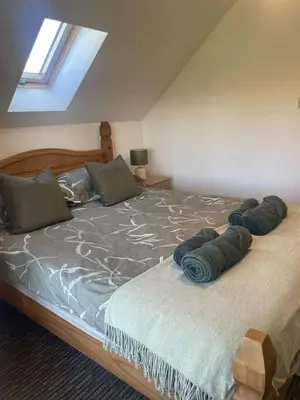 a bedroom with a bed with blue pillows on it at Cottage in Synod Inn with Hot Tub in Synod