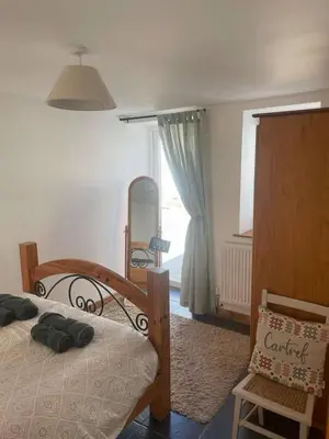 a bedroom with a bed and a chair and a window at Cottage in Synod Inn with Hot Tub in Synod