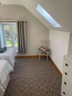 a bedroom with a bed and a dresser and a window at Cottage in Synod Inn with Hot Tub in Synod