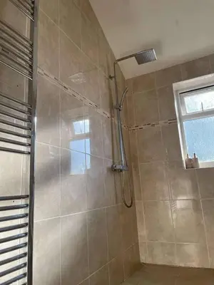 a shower stall in a bathroom with a window at Cottage in Synod Inn with Hot Tub in Synod