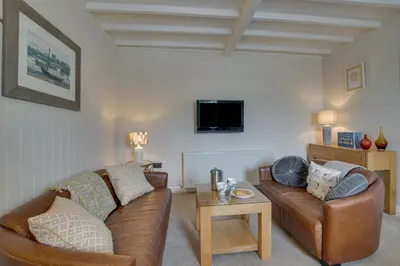 a living room with two leather couches and a tv at 2 Bed in Aberaeron oc-bow173 in Aberaeron