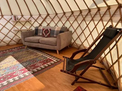 a room with a couch and a chair in a yurt at Hinton land glampsite in Peterchurch