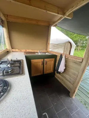 a kitchen with a sink and a stove in a tent at Hinton land glampsite in Peterchurch