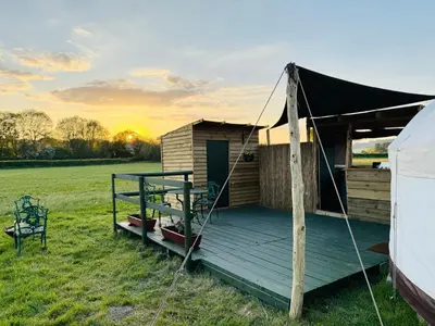 a yurt with a deck in a field at Hinton land glampsite in Peterchurch