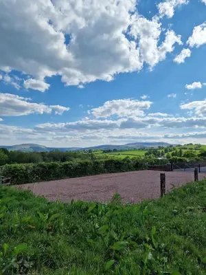 a dirt road in a field under a cloudy sky at Oak Moor Shepherd Hut - Brecon Beacons, LD3 7TD in Tal-y-llyn
