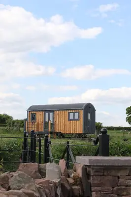 a tiny house on the tracks in a field at Long Meadow Shepherd Hut - Brecon Beacons, LD3 7TD in Tal-y-llyn