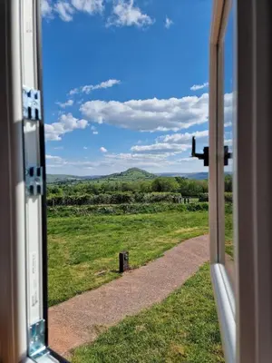 a window view of a field from a train at Long Meadow Shepherd Hut - Brecon Beacons, LD3 7TD in Tal-y-llyn