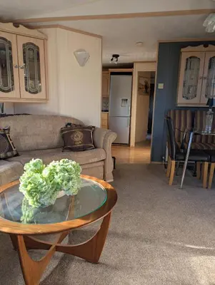 a living room with a couch and a table at Aberystwyth holiday village walking distance to beach, town great outside space parking next to property in Aberystwyth