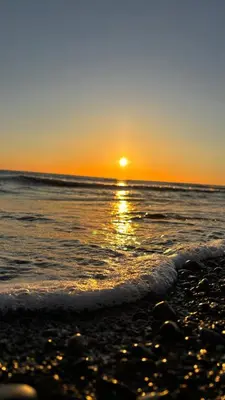 a sunset on a beach with the ocean at Welsh Bayview Retreat 2-Bed Caravan & 2-Bed Chalet at Clarach Bay Holiday Village in Aberystwyth
