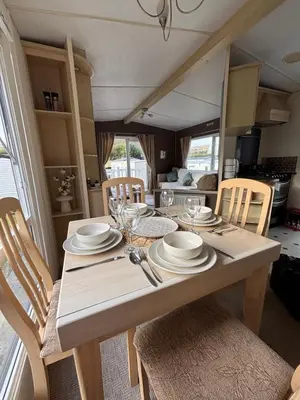 a table with plates and glasses on it in a kitchen at Welsh Bayview Retreat 2-Bed Caravan & 2-Bed Chalet at Clarach Bay Holiday Village in Aberystwyth
