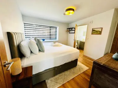 a bedroom with a bed with white sheets and pillows at Ynyslas View in Aberdyfi