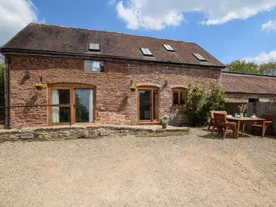 a brick house with a table and chairs in front of it at 2 Bed in Craven Arms oc-96046 in Tugford