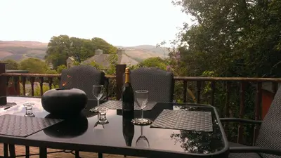 a table with wine bottles and glasses on a balcony at Parkway Chalet - Pennal, Powys, Wales nr Aberdovey in Pennal
