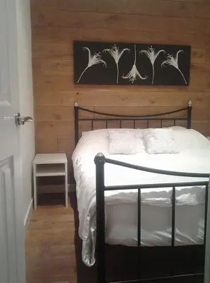 a bedroom with a bed with a wooden wall at Parkway Chalet - Pennal, Powys, Wales nr Aberdovey in Pennal