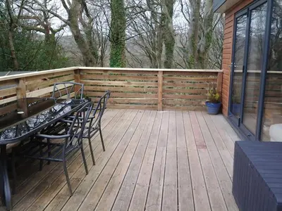 a wooden deck with a table and chairs on it at Parkway Chalet - Pennal, Powys, Wales nr Aberdovey in Pennal