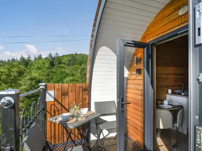 an outdoor patio with a table and chairs on a balcony at Luna Holiday Pod - Uk48590 in Church Stretton