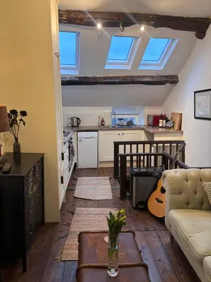 a living room with a couch and a kitchen with skylights at The Little Laura Ashley House in Machynlleth