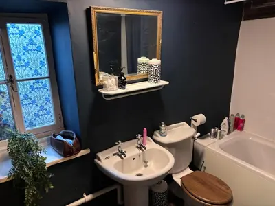 a bathroom with a sink and a toilet and a tub at The Little Laura Ashley House in Machynlleth