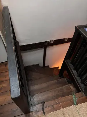 an old wooden stairway with a metal rail at The Little Laura Ashley House in Machynlleth