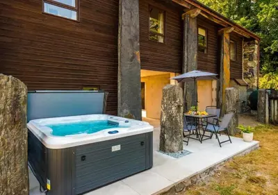 a hot tub on a patio next to a house at Peaceful Barn Near Cader Idris in Dolgellau