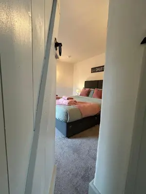 a bedroom with a bed and a door leading into a room at Brewe's Loft in Farden