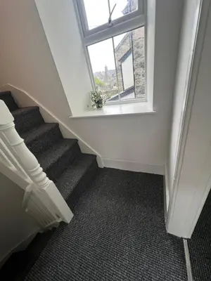 a stairway with a window and a stair case at Cosy Cader Cottage in Dolgellau